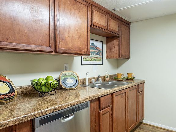 The kitchen with the wood-like flooring and faux granite countertops.