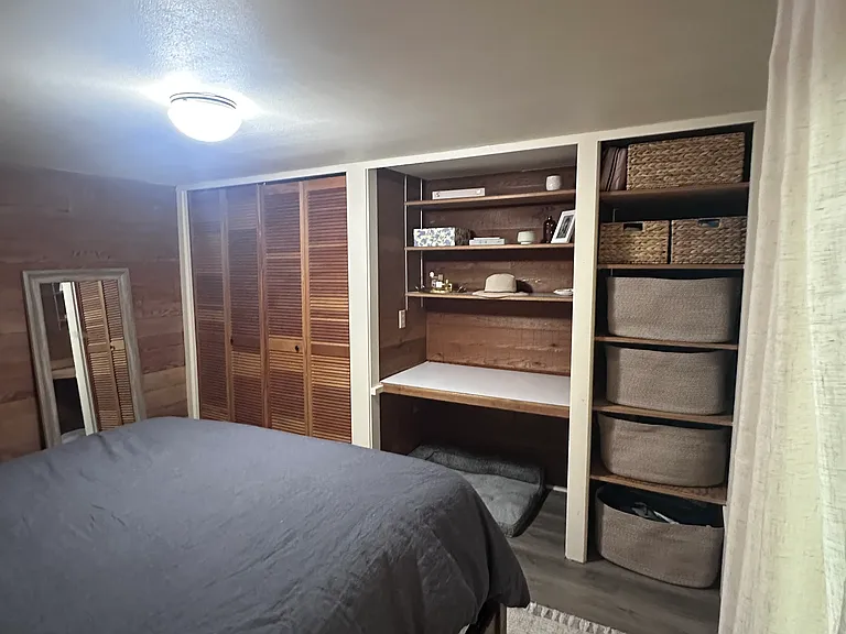 Second bedroom comfortably fits a queen-size bed and features a built-in desk, closet, and shelving. Furniture shown belongs to the current tenant and is not included.