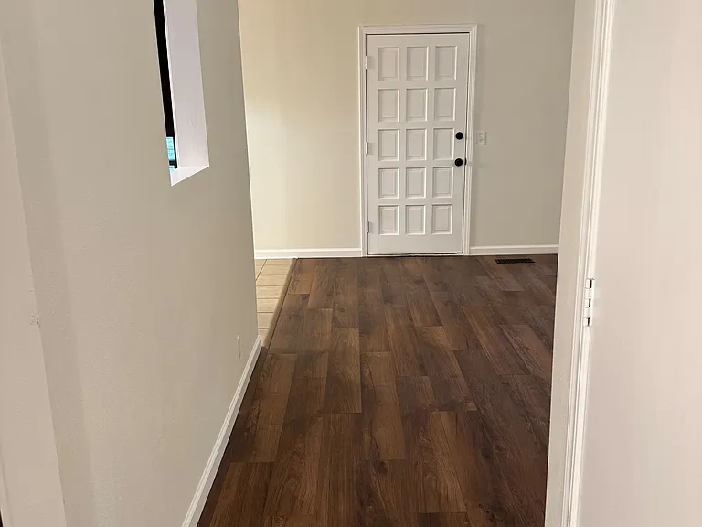 Hallway from front sitting area flows into kitchen and living room