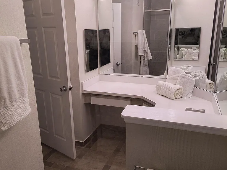Primary en suite bathroom with linen closet, new lighting, new toilet. Ceramic tile floor.