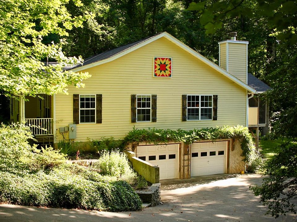 View of the house and garage with terraced flower garden