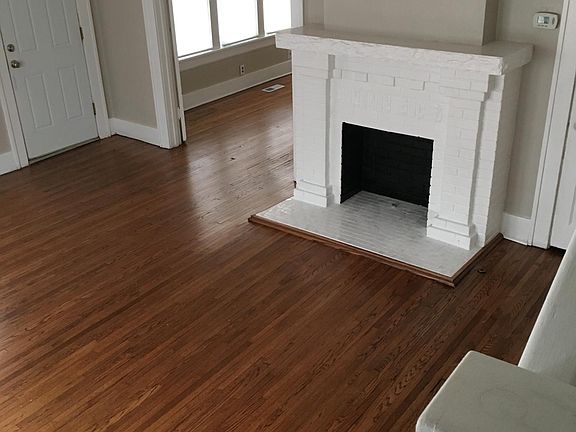 Living room with gleaming floors and new tile around fireplace