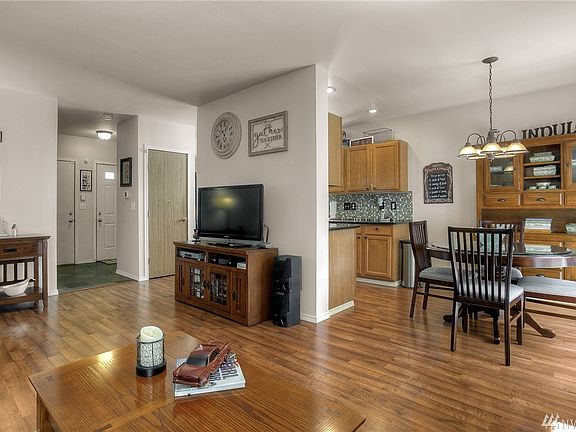 This photo shows the wonderful floor plan in this home from living to dining to kitchen.  The slate entry and exterior and garage doors are to the back of this photo.  This home is warm and inviting throughout!