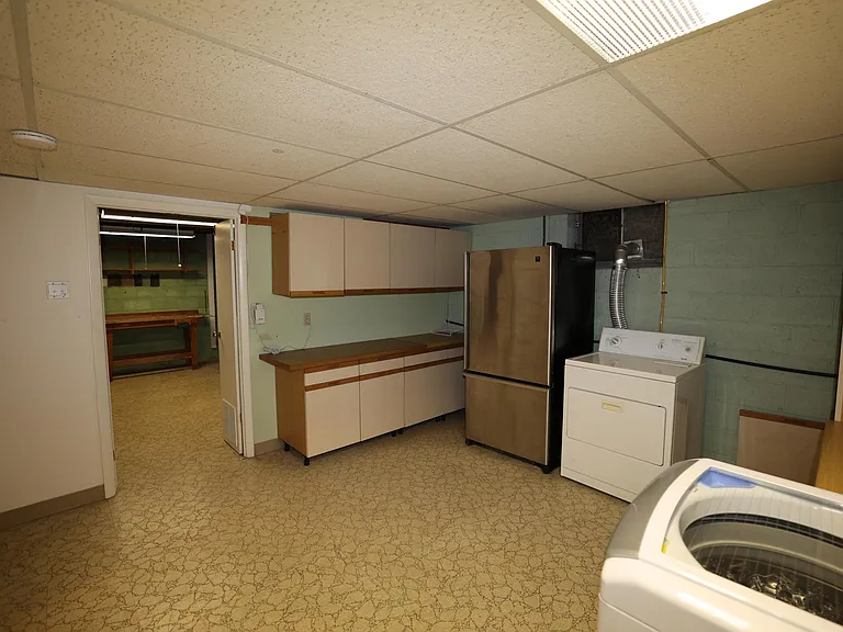 Laundry room leads into workbench and storage area