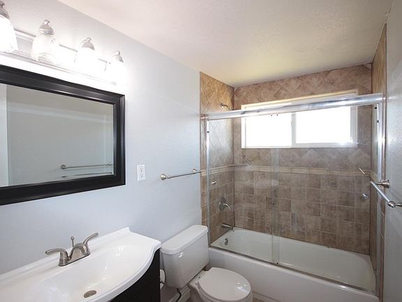 Custom-tiled tub surround with tub enclosure.