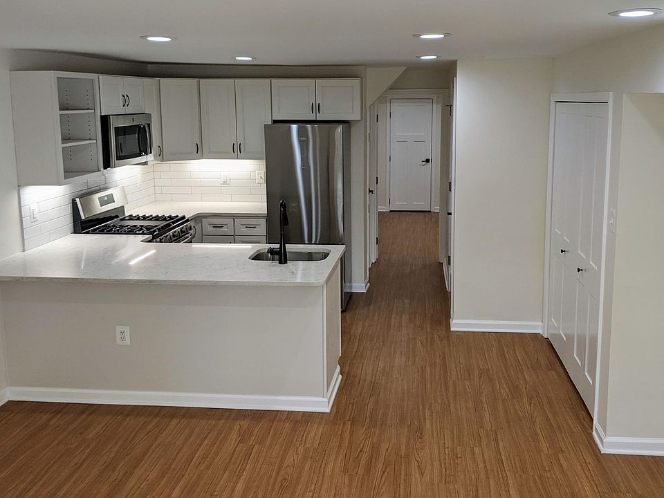 View from front of apartment shows laundry closet, kitchen, and hallway through to bedroom
