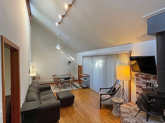 furnished living room and dining room. High Ceiling with wood burning stove. Front windows facing front Redwoods with covered balacony