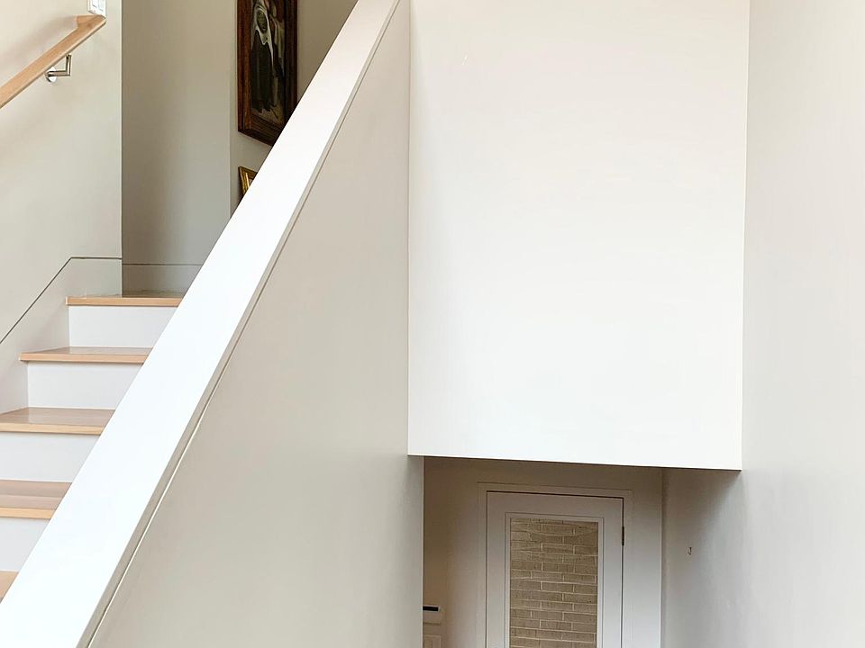 Staircase landing, looking toward front entry and apartment upstairs.