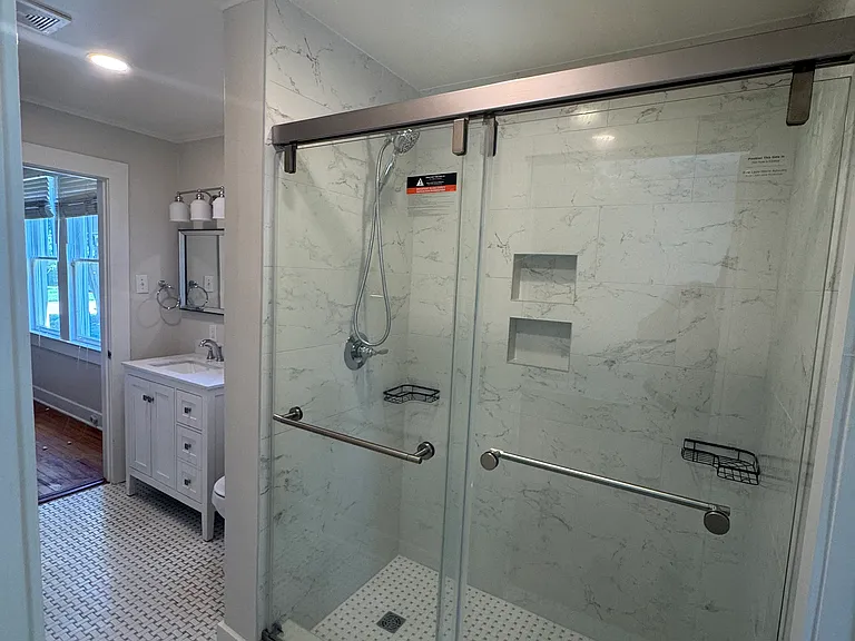 New updated bathroom with walk-in shower, new toilet and vanity, as well as new tile flooring