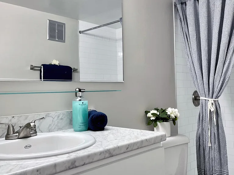 Step into luxury with upgraded bathrooms featuring chic marble-inspired vanities, timeless white cabinetry, radiant mirrors, and a white-tiled walk-in shower (available in select bathrooms).