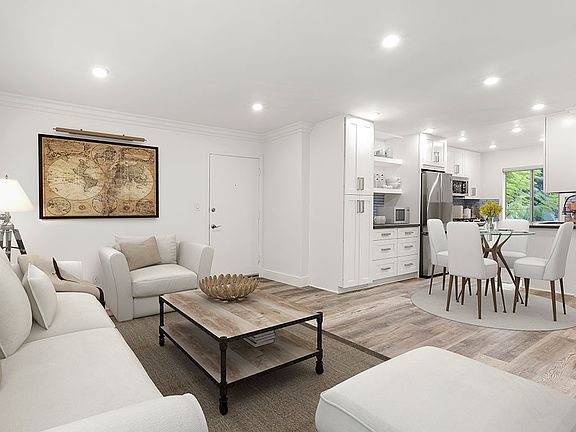 Hardwood floored living room with view of spacious kitchen.