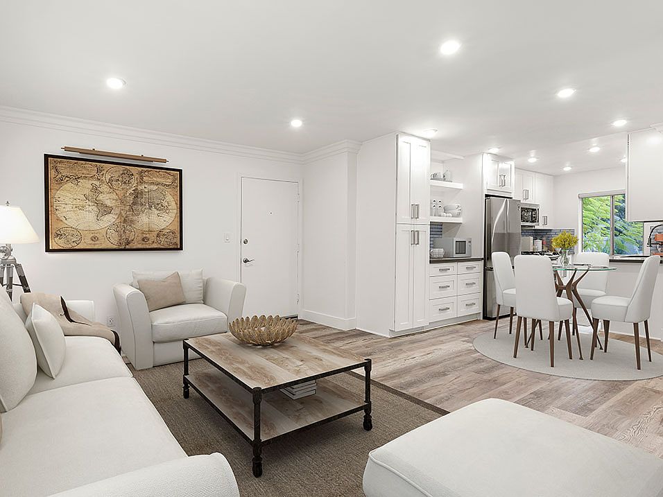 Hardwood floored living room with view of spacious kitchen.