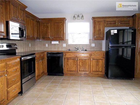 Kitchen with Oak Cabinets, Electric Range, Micro Wave, Dish Washer, Refrigerator and Tile Flooring.