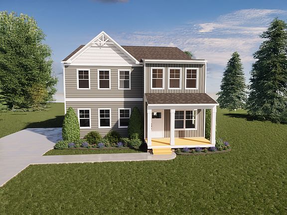 Two-story gray house with white trim, front porch, driveway, and green lawn surrounded by trees.