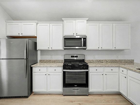 The kitchen is sure to impress with white cabinetry and granite countertops.