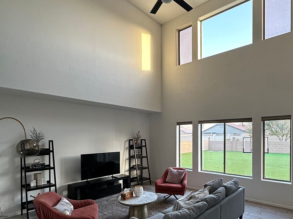 The living room: sofa, TV, two chairs, a coffee table, and bookshelves.