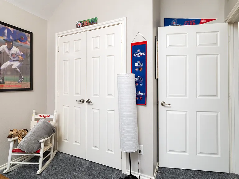 Fun sports-themed bedroom with a comfy queen bed, bold decor, and seating chest. A playful space perfect for kids, teens, or fans looking to relax and unwind.