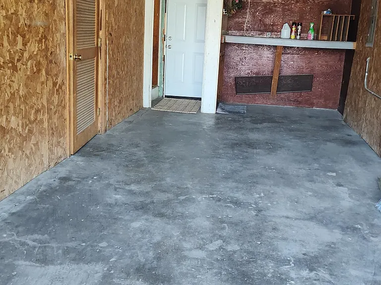 1 car garage with workbench and entrance to laundry room.