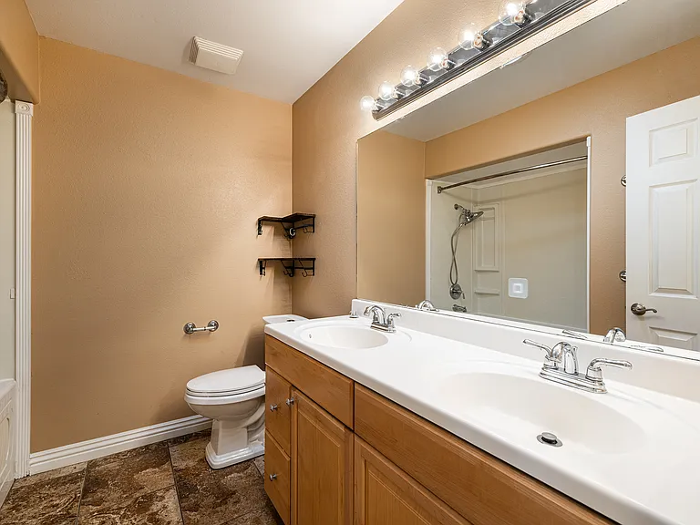 Hall Bathroom with dual sinks and jacuzzi style tub