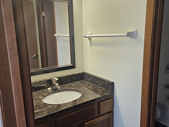 Nice bathroom with tub/shower and stool separate from the vanity area.