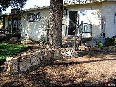 Firepit with spring green hills beyond fence