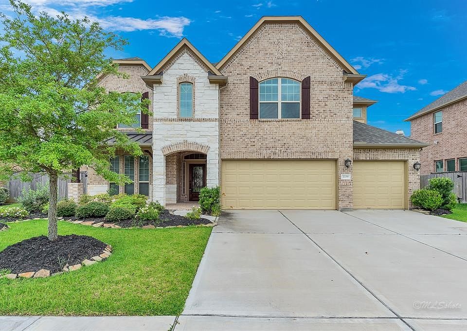 Lovely brick and stone exterior with 3 car side by side garage