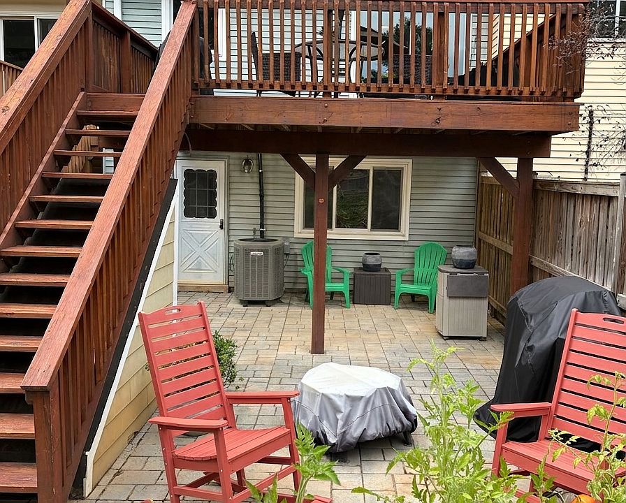 Private Outdoor Sanctuary: Custom stone paver patio with built-in French drain system to ensure quick drainage. Enjoy versatile outdoor living with cozy seating around the fire pit, a sheltered area under the deck, and direct stair access to the deck.