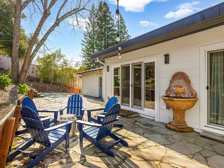 Backyard with a fire pit and string lights, accessible from bedrooms and dining room.