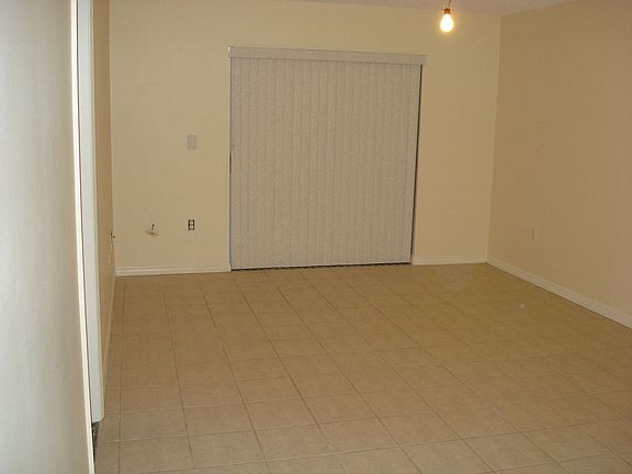Living room with double doors to back yard that lead to pool. New floor tile.