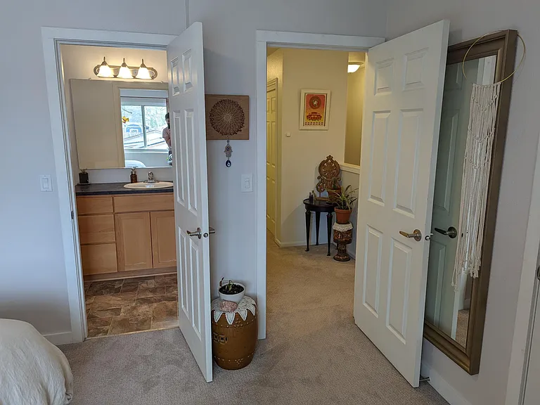 Inside primary bedroom looking out into hallway and ensuite bathroom.