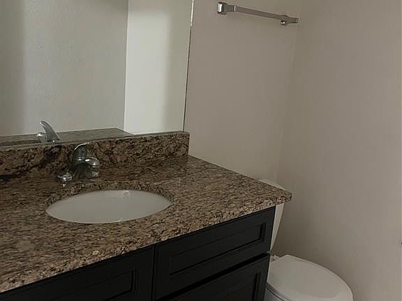Bathroom featuring tile patterned floors, vanity, and toilet