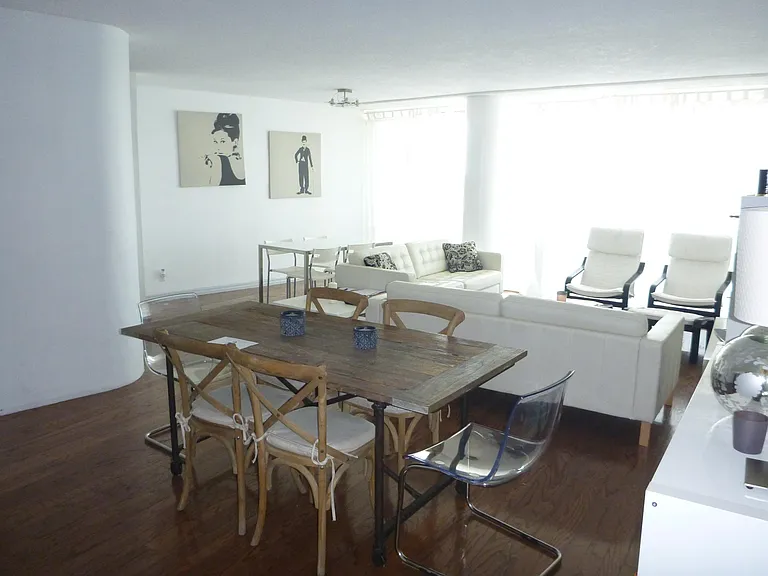 View of living room with TWO dining areas set up in unit and view of wood floors