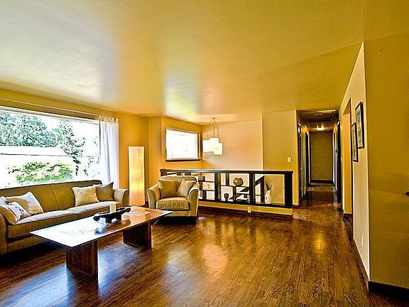 The living room is filled with sunlight from the full-wall picture window