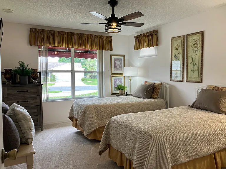 Guest bedroom with TV and walk in closet. USB ports in nightstands. Remote controlled fan