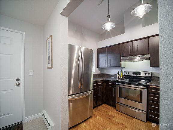 New lighting accentuates the vaulted ceilings in the kitchen.  True vented hood.>