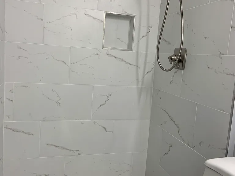 Master bathroom stall shower with gorgeous tiling, fog-less mirror and more.
