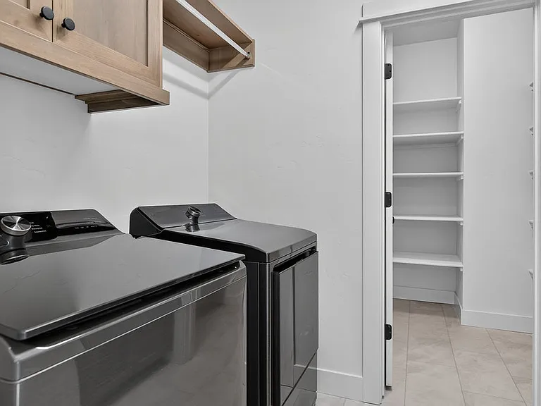 Large laundry room with additional walk in storage room with built in shelves