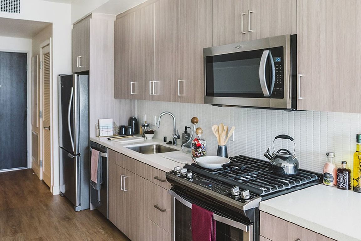 Gally Kitchens with gorgeous cabinetry, tile backsplash and quartz countertops.