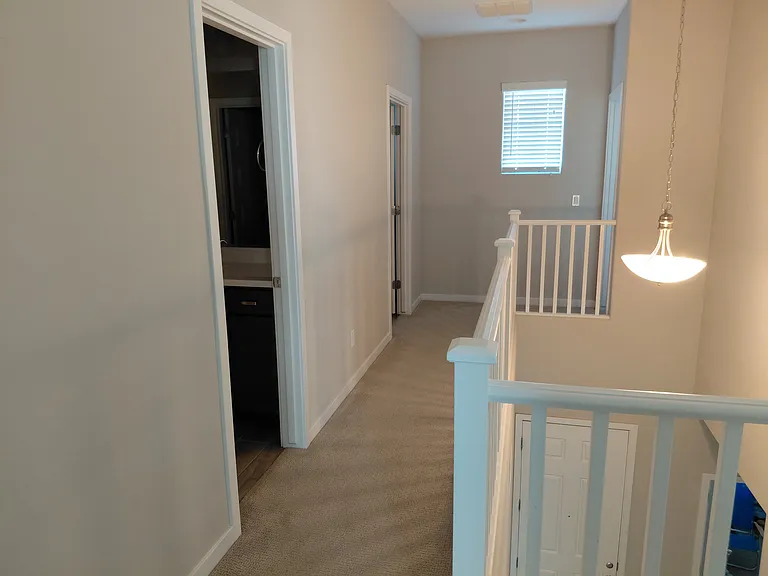 Upstairs hallway. Upstairs bathroom closest and laundry farthest on left. Larger upstairs bedroom at the end on the right.