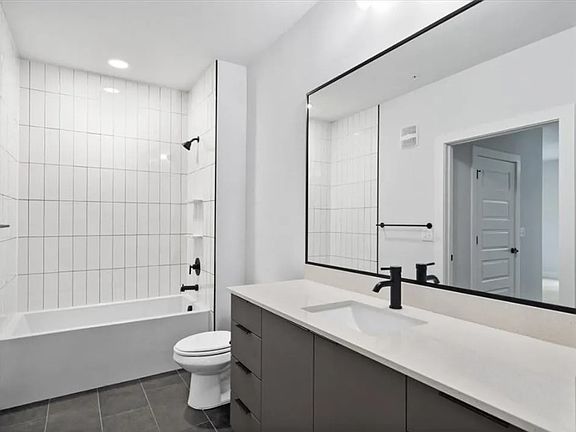 Modern bathroom large mirror, and full-sized soaking tub.