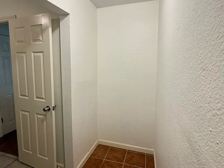 Storage area; photo looks back into the house (exterior wall behind you), laundry room floor visible on the left.