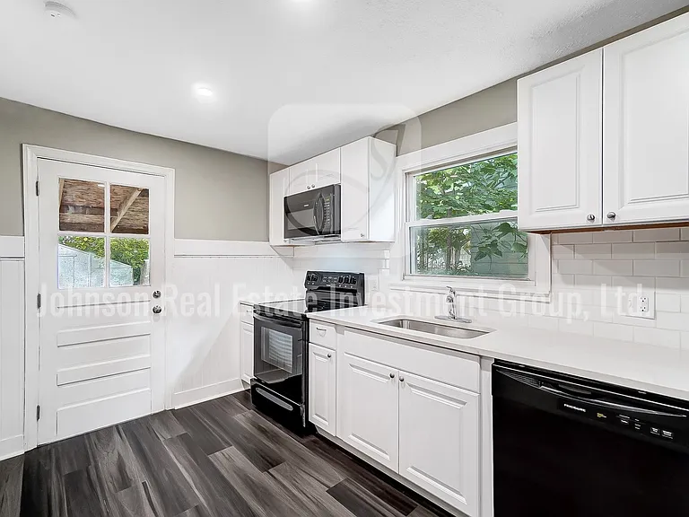 Stunning remodeled kitchen with black appliances and white quartz countertops!