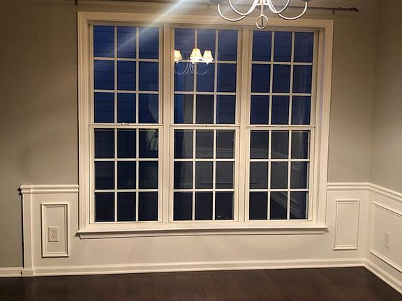 Large formal dining/living area at front entrance with high ceilings, windows on two walls letting in plenty of light and fresh air