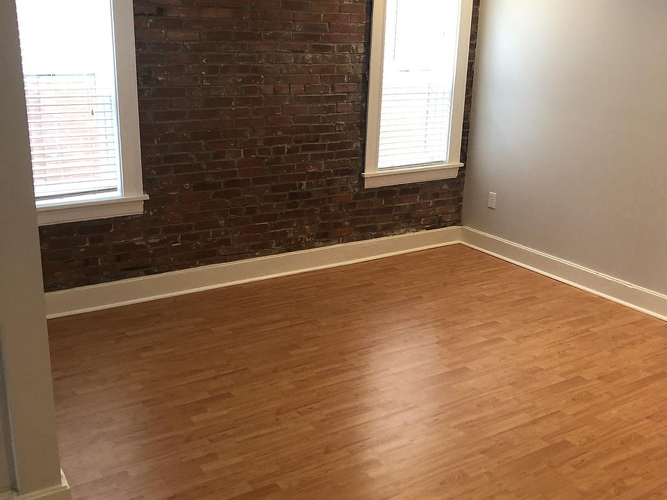 Spacious living room with exposed brick wall