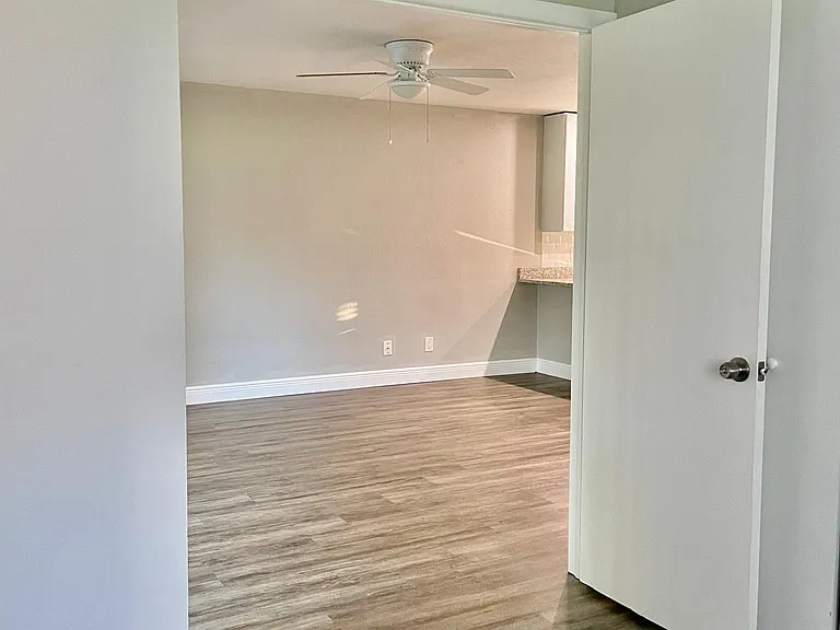 Large bedroom with double doors open to living space.