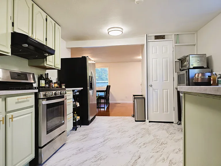 Newly installed sturdy vinyl flooring, large pantry at the corner of the kitchen, mobile spice rack stored under the countertop