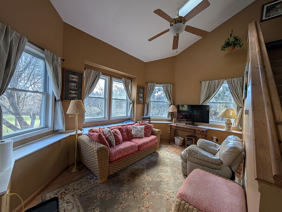 Sunroom lounge with great natural light, TV, and cozy seating.