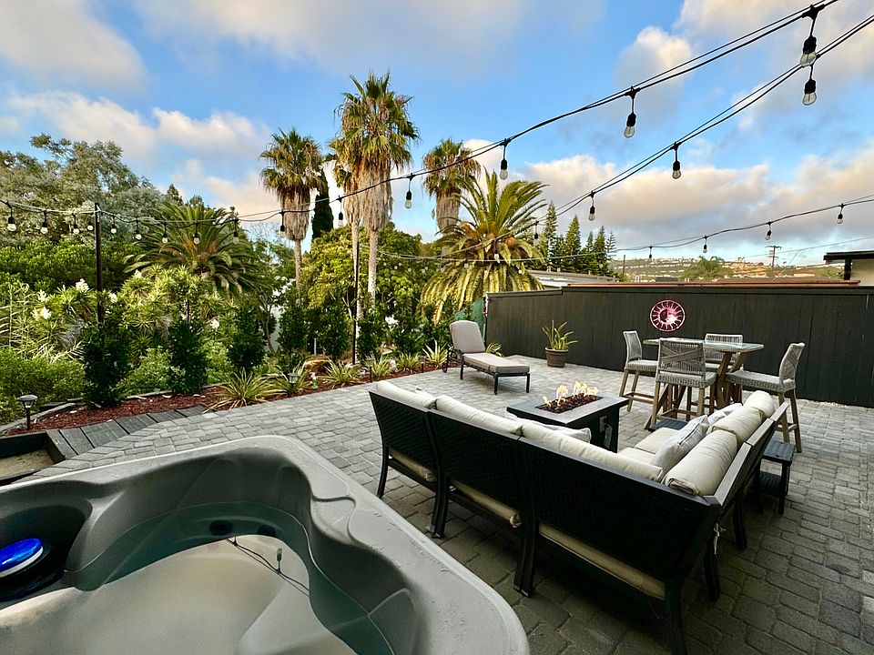 4 person hot tub, gas fire pit, outdoor seating, and outdoor dining table nestled in the canyon, with string lights and gorgeous views