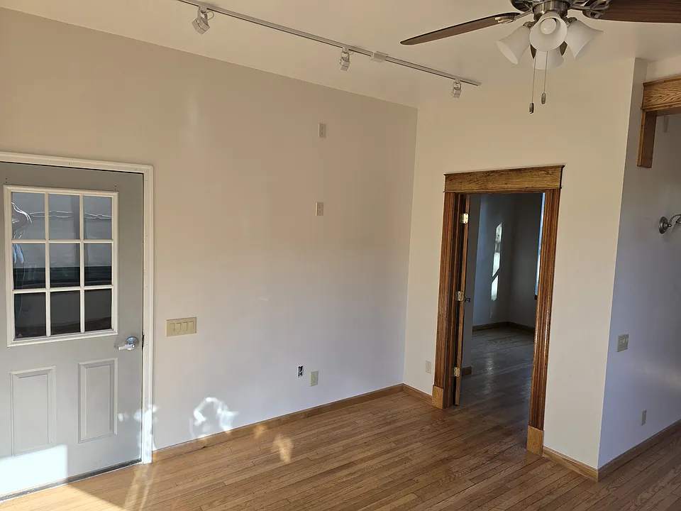 Entrance from front stairway and front bedroom in living room.