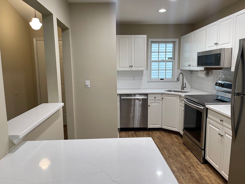 Bright kitchen with quartz countertops and stainless steel appliances; open to the dining/family room